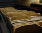 Ряд старых папок с кольцевыми переплётами в слабо освещённой комнате.
