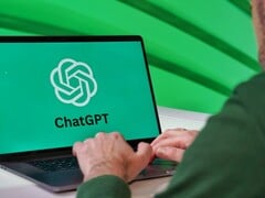 Мужчина печатает на ноутбуке, на экране которого виден логотип ChatGPT