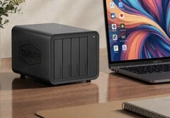 На изображении показан NAS Terramaster D8 Hybrid 2 рядом с ноутбуком на деревянном столе