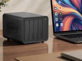 На изображении показан NAS Terramaster D8 Hybrid 2 рядом с ноутбуком на деревянном столе 