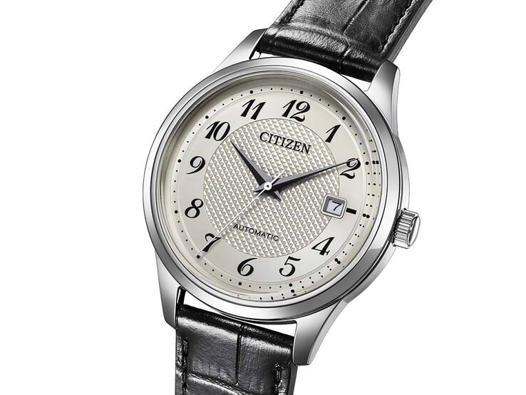 Вид спереди автоматических часов Citizen NJ0250-01B с серебристым циферблатом, чёрными арабскими цифрами, окошком даты и чёрным кожаным ремешком.