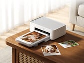 Новый настольный фотопринтер 2 стоит на Youpin около 103 долларов. На снимке: рекламное изображение, демонстрирующее принтер в действии.
