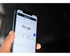 Фотография руки, держащей смартфон с открытой главной страницей Google Search на экране. (Источник изображения: Solen Feyissa на Flickr)