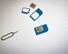 SIM-карты трех размеров и штифт для извлечения на белом фоне