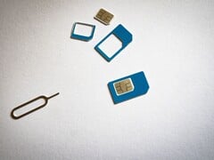 SIM-карты трех размеров и штифт для извлечения на белом фоне