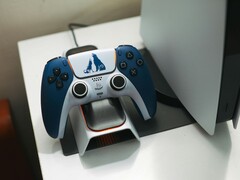 Изготовленный на заказ контроллер DualSense на тему God of War лежит на зарядной док-станции перед консолью PlayStation 5. (Источник изображения: FOX ^.ᆽ.^= ∫)