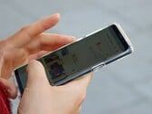 Рука держит смартфон на базе Android, на экране которого отображается приложение с картой.