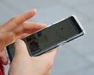 Рука держит смартфон на базе Android, на экране которого отображается приложение с картой.
