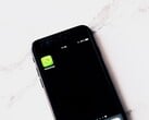 Смартфон на белом столе с открытым приложением WhatsApp