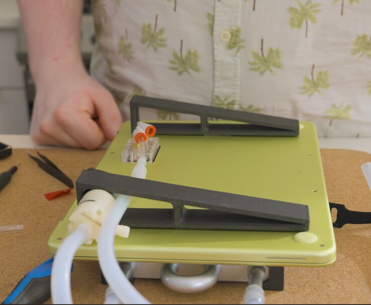 Модифицированный MacBook Neo с внешним насосом и трубками для жидкостного охлаждения DIY