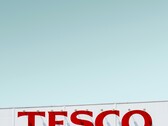 Внешняя вывеска Tesco сфотографирована на фоне ясного неба (Источник изображения: Simone Hutsch via Unsplash)