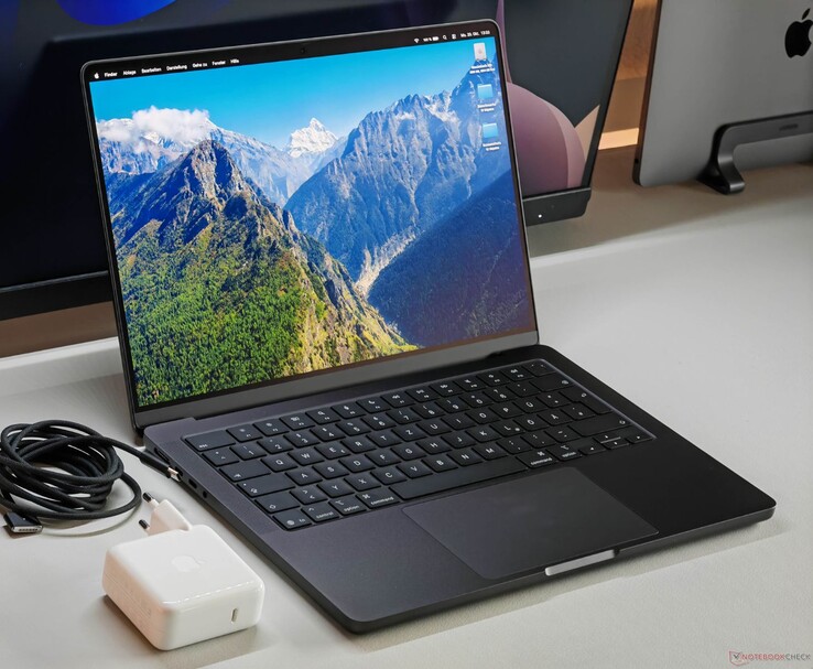 Apple MacBook Pro с чипом M5 на столе вместе с зарядным устройством и кабелем. (Источник изображения: Notebookcheck)