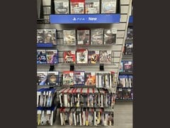 Проход в магазине GameStop, заполненный физическими играми для PS3