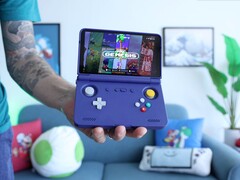 Русс из Retro Game Corps держит в руках портативную игровую консоль Retroid Pocket Flip 2 фиолетового цвета, на экране которой отображается интерфейс эмулятора Sega Genesis. (Источник изображения: Retro Game Corps на YouTube)
