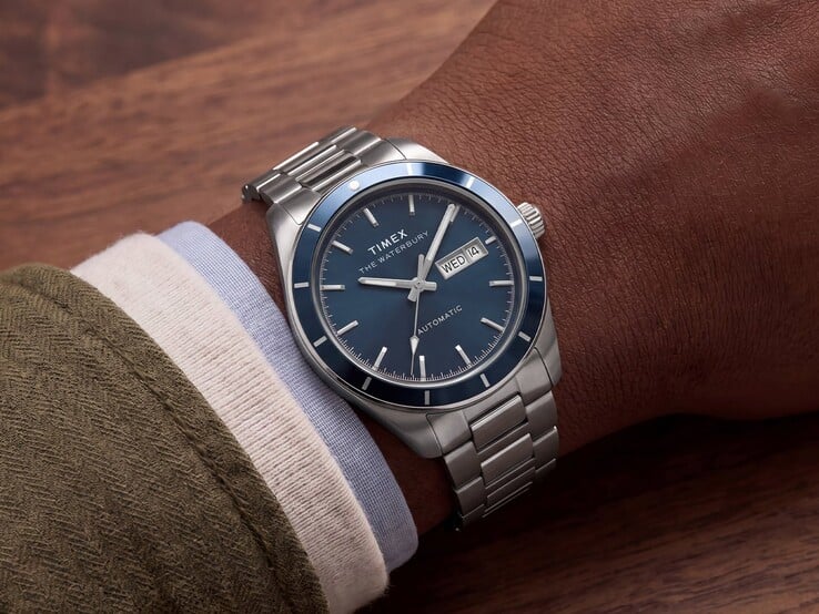 Часы Timex Waterbury Heritage Automatic с синим эмалевым циферблатом на запястье, демонстрирующие корпус серебристого цвета и браслет из нержавеющей стали.