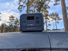 Bluetti Elite 100 V2 на био-основе на крыше автомобиля с соснами на заднем плане