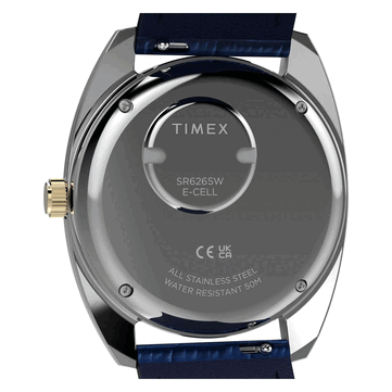 Вид сзади на Timex Q 1976 Day and Date в золотистом цвете: задняя крышка корпуса из нержавеющей стали, батарейный отсек и маркировка водонепроницаемости до 50 метров.