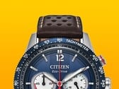 Крупный план хронографа Citizen Racing CA4716-09L, на котором видны синий тахиметрический безель, темно-синий циферблат с серебристыми стрелками и индексами, три дополнительных циферблата, красная центральная секундная стрелка и коричневый перфорированный кожаный ремешок на желтом фоне.
