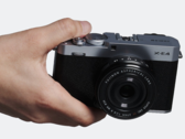 Компактная фотокамера со сменными объективами Fujifilm X-E4 в руках