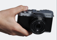 Компактная фотокамера со сменными объективами Fujifilm X-E4 в руках