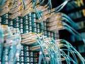 Синие оптоволоконные кабели с белыми разъёмами, подключенные к патч-панели в центре обработки данных