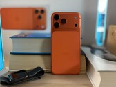 Apple iPhone 17 Air в оранжевой отделке, демонстрирующий дизайн задней панели и модуль камеры, расположенный на сложенных стопкой книгах
