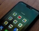 Смартфон на деревянном столе с открытой папкой приложений Google