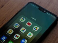 Смартфон на деревянном столе с открытой папкой приложений Google