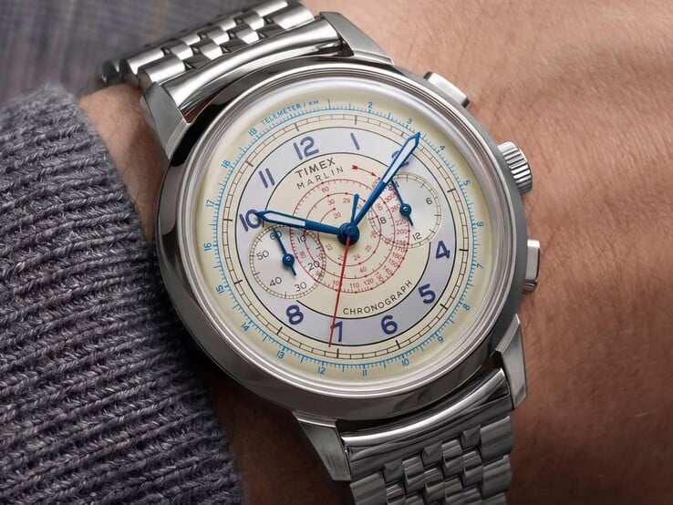 Хронограф Timex Marlin Neo Classic с кремовым циферблатом, синими стрелками и браслетом из нержавеющей стали, надетый на запястье.