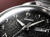 Крупный план чёрного циферблата Casio MTP-E735AR с замысловатым узором в стиле арабески, накладными восточно-арабскими цифрами, полированными стрелками серебристого цвета и указателем дня недели и даты в положении «3 часа».
