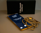 Фотография телефона Trump Phone T1 вместе с коробкой и кабелем.