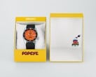 Автоматические часы Seiko 5 Sports x Popeye HDB013 с оранжевым циферблатом, расположенные рядом с желтой подарочной коробкой ограниченной серии.