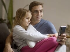 Отец и его дочь, вместе смотрящие на смартфон