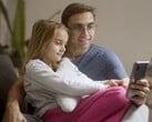 Отец и его дочь, вместе смотрящие на смартфон