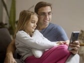 Отец и его дочь, вместе смотрящие на смартфон