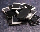 Куча выведенных из эксплуатации смартфонов на серой поверхности