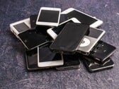 Куча выведенных из эксплуатации смартфонов на серой поверхности