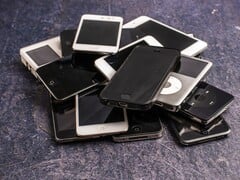 Куча выведенных из эксплуатации смартфонов на серой поверхности