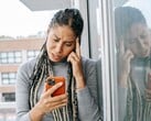Женщина с серьёзным выражением лица смотрит на свой смартфон