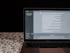 Ноутбук с открытым окном чата с ИИ на тёмном фоне; стоковое изображение, иллюстрирующее локальное использование ИИ без подключения к облаку.