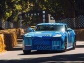 Электромобиль Jaguar Type 01 в камуфляжной расцветке «Blue Exuberant Modernism» мчится мимо стартовой решетки на гонке Goodwood Hill Climb